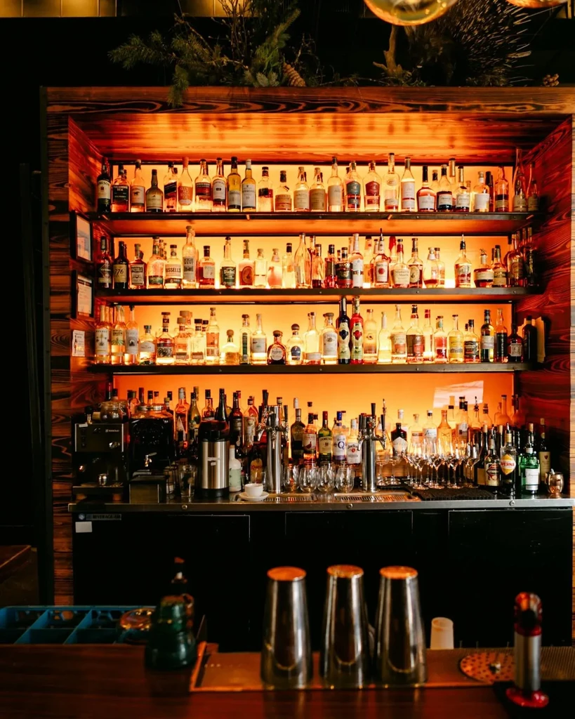 A well-stocked bar with warmly lit liquor bottles on dark shelves.