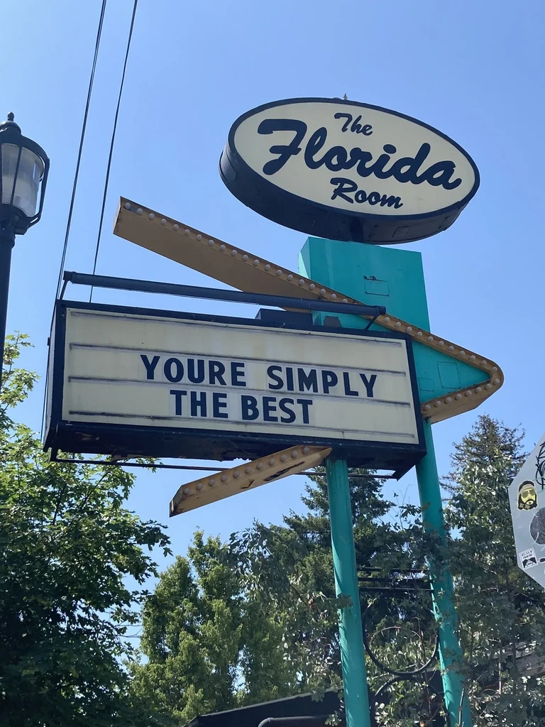 Retro "The Florida Room" sign on turquoise pole, marquee "YOU'RE SIMPLY THE BEST".