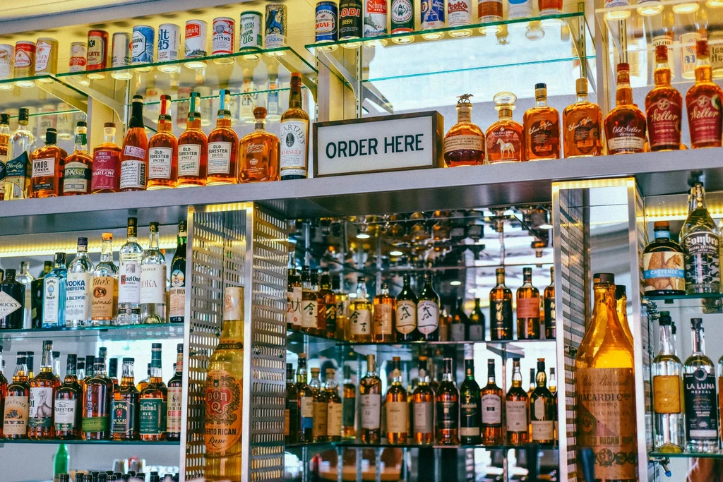 Illuminated shelves of spirits and beer bottles, with an "ORDER HERE" sign.