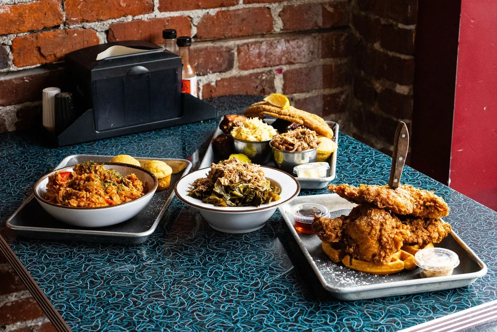 Southern comfort food meal featuring fried chicken, waffles, and mac and cheese.
