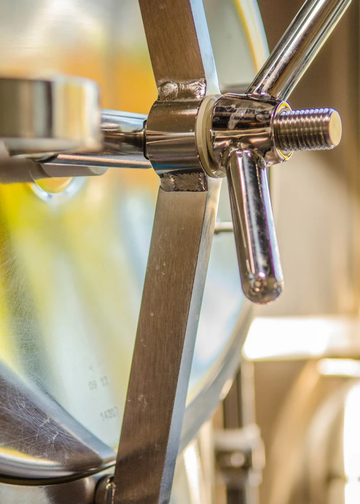 Polished industrial equipment with star-shaped handle and prominent bolt.