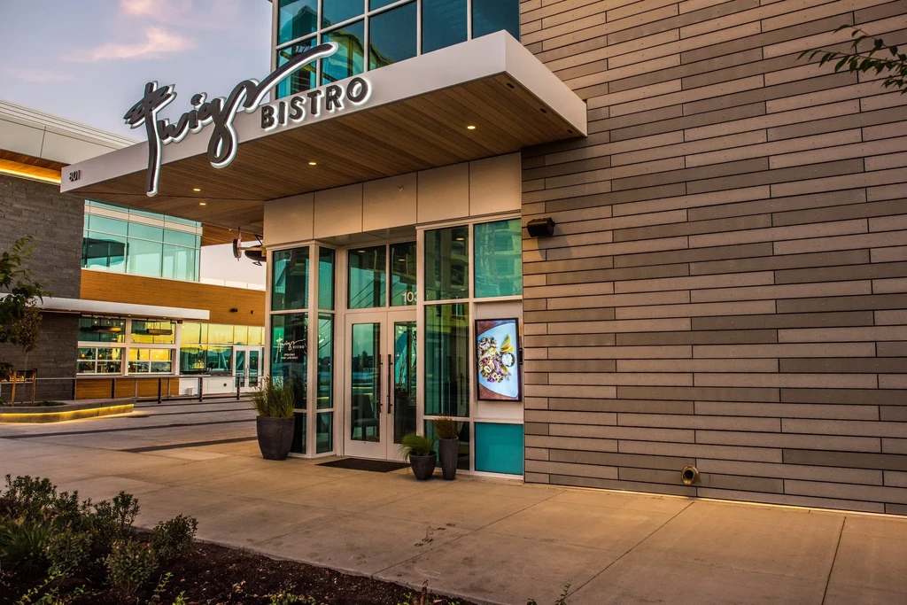 Modern Twig Bistro entrance with sign, glass, wood, and digital display.
