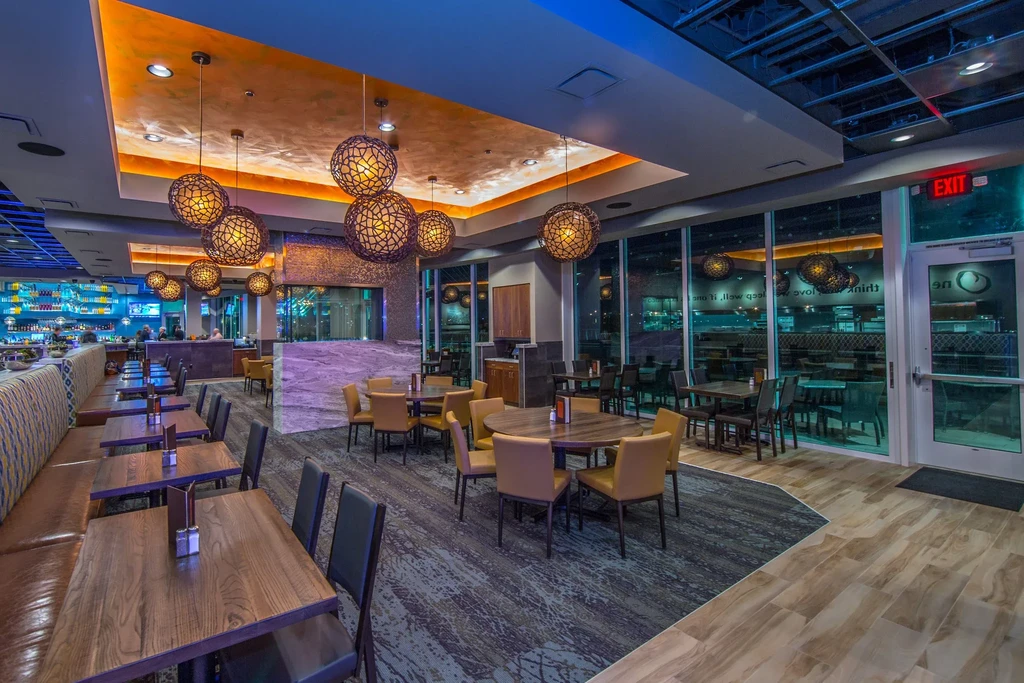 Modern upscale restaurant interior with varied seating and warm lighting.