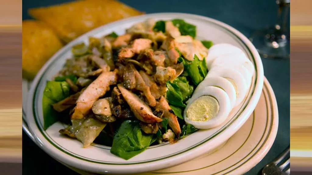 Grilled chicken salad with hard-boiled eggs and greens.