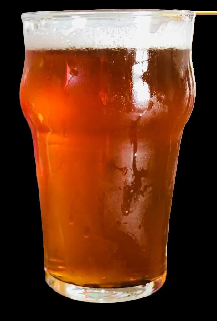 Amber beer in a condensation-covered pint glass with white foam.