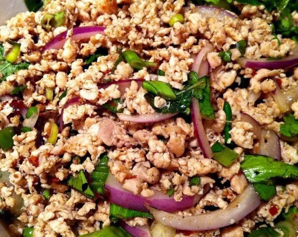 Ground meat Larb salad with red onion and green herbs.