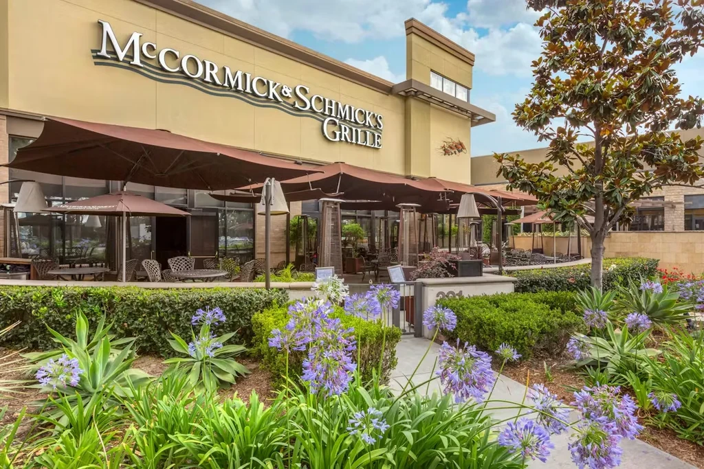 McCormick & Schmick's Grille exterior with outdoor patio and purple flowers.