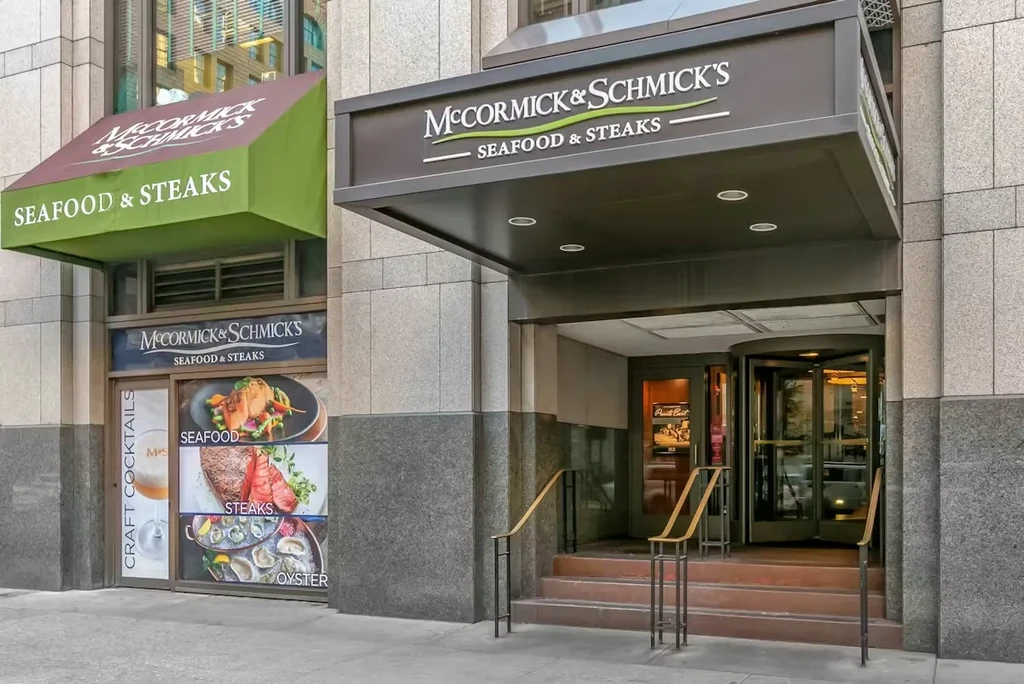 McCormick & Schmick's restaurant entrance, with illuminated sign and food displays.