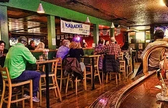 Lively bar interior with patrons enjoying a karaoke night event.