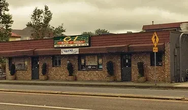 Brick exterior of CJ's Bar & Grill, with karaoke and live music signs.