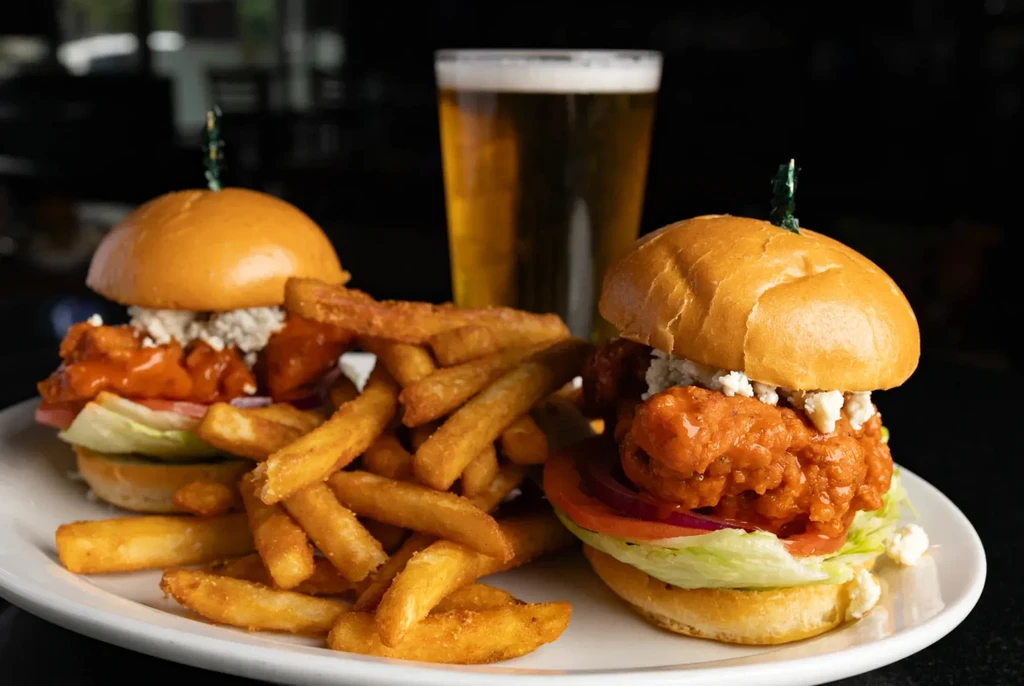 Two buffalo fried chicken sliders with blue cheese, fries, and beer.