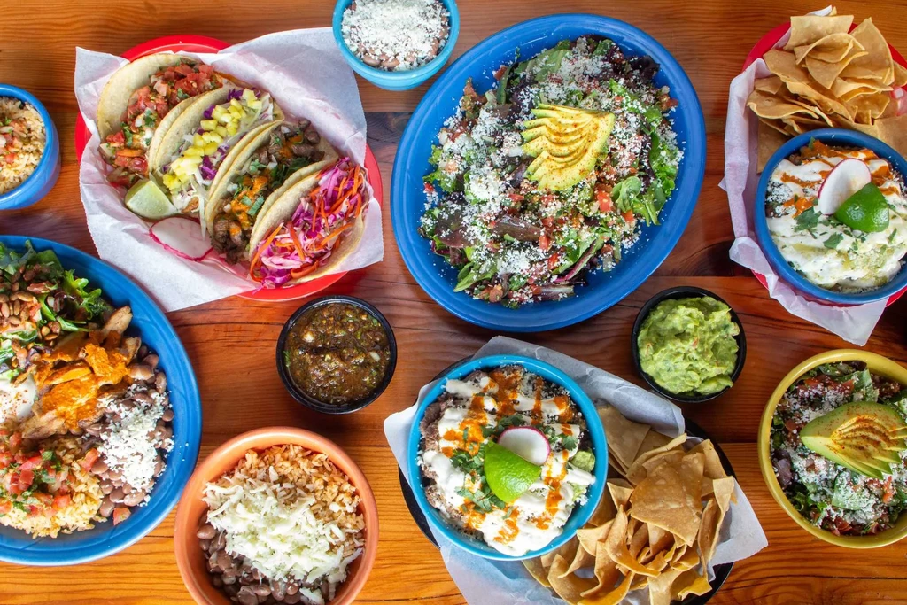 Overhead view of colorful Mexican and Tex-Mex dishes on a table.
