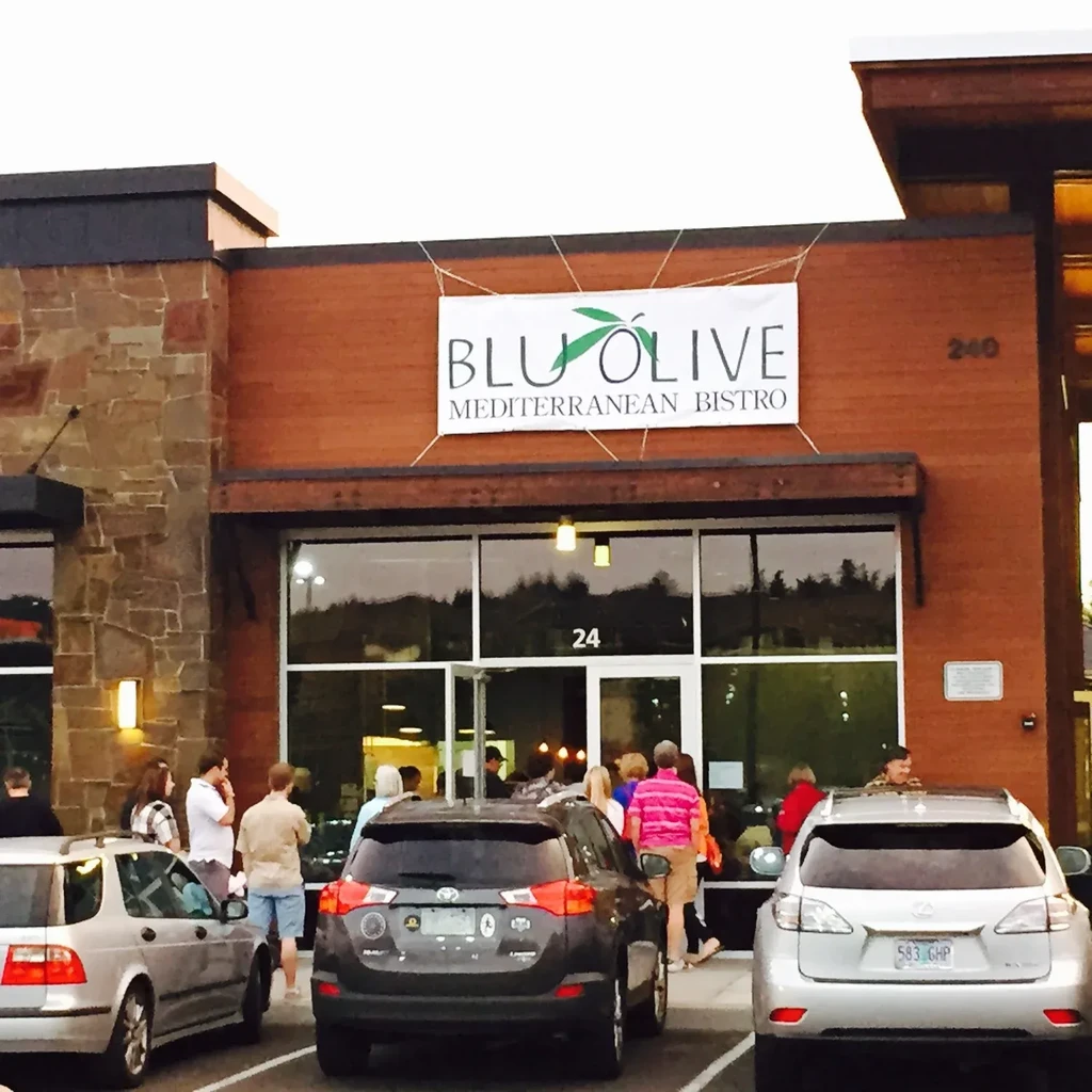 Modern BLU OLIVE Mediterranean Bistro exterior with people and cars.