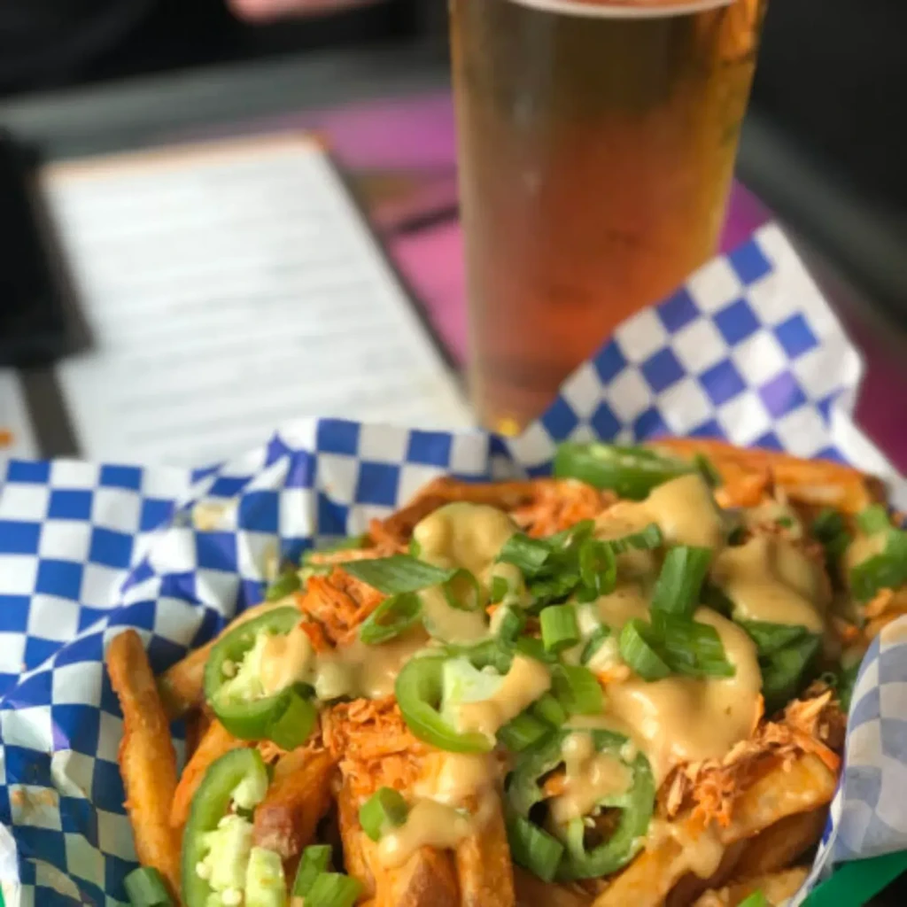 Loaded fries with shredded meat, jalapeños, green onions, and beer.