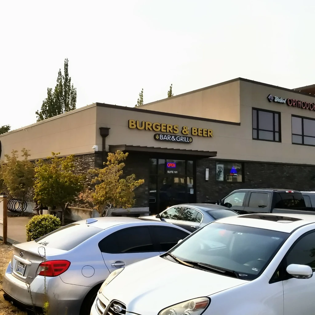 Daytime exterior of "BURGERS & BEER BAR & GRILL" commercial building.