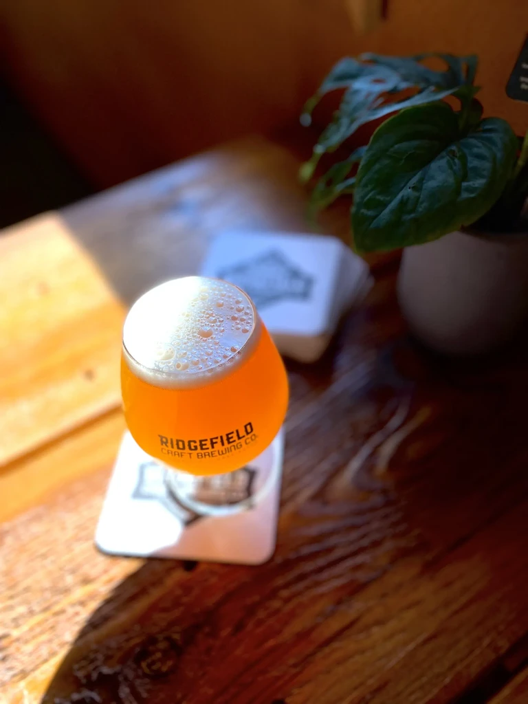 Glass of amber craft beer from Ridgefield Brewing Co. on rustic table.