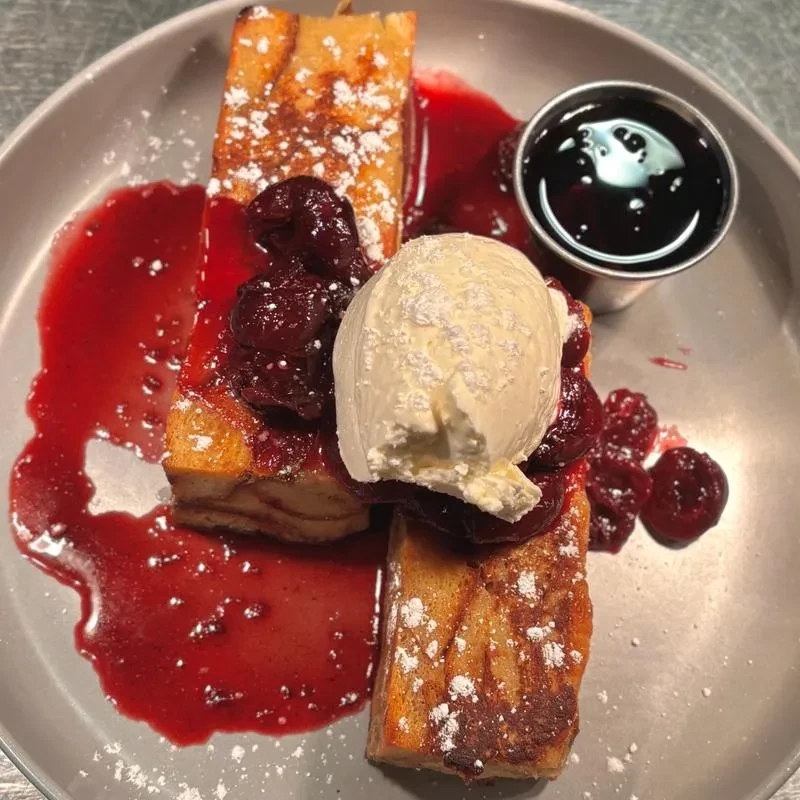 French toast sticks with berry compote, ice cream, and powdered sugar.