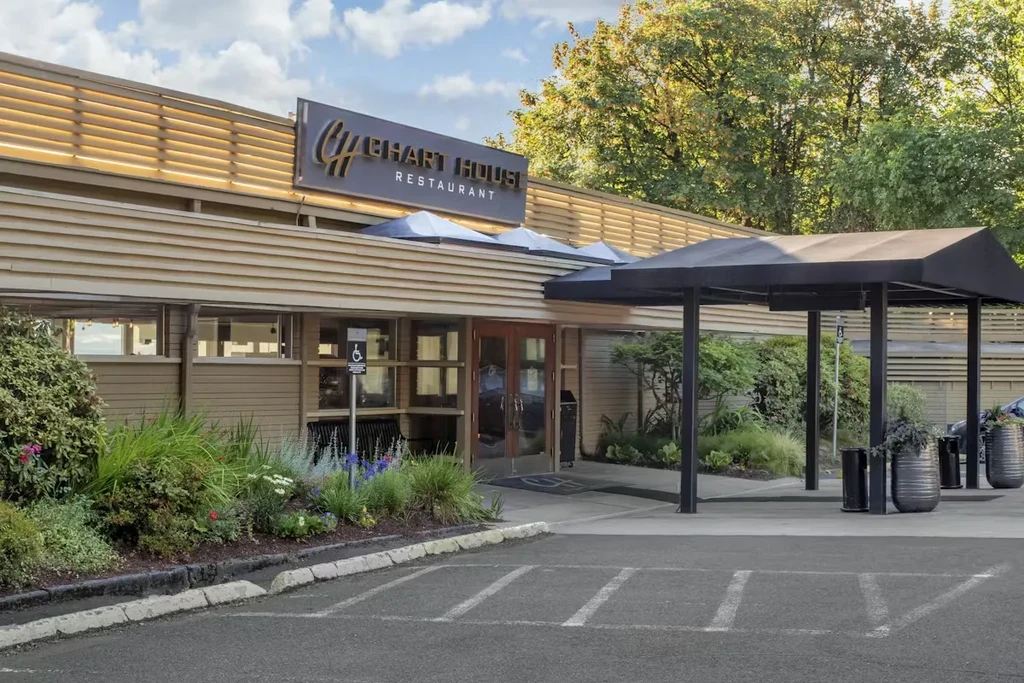 Chart House Restaurant exterior, beige building, colorful garden, accessible parking.