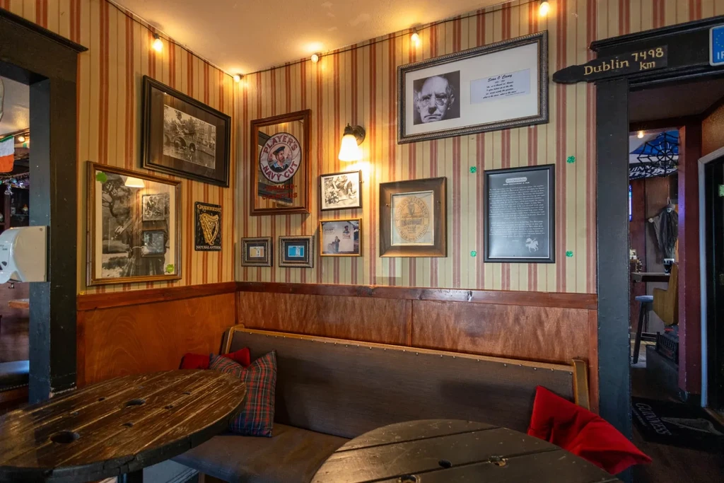 Cozy traditional pub with framed pictures, wood panels, and spool tables.