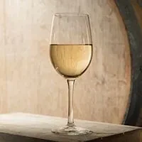 Glass of golden white wine on a rustic wooden background.