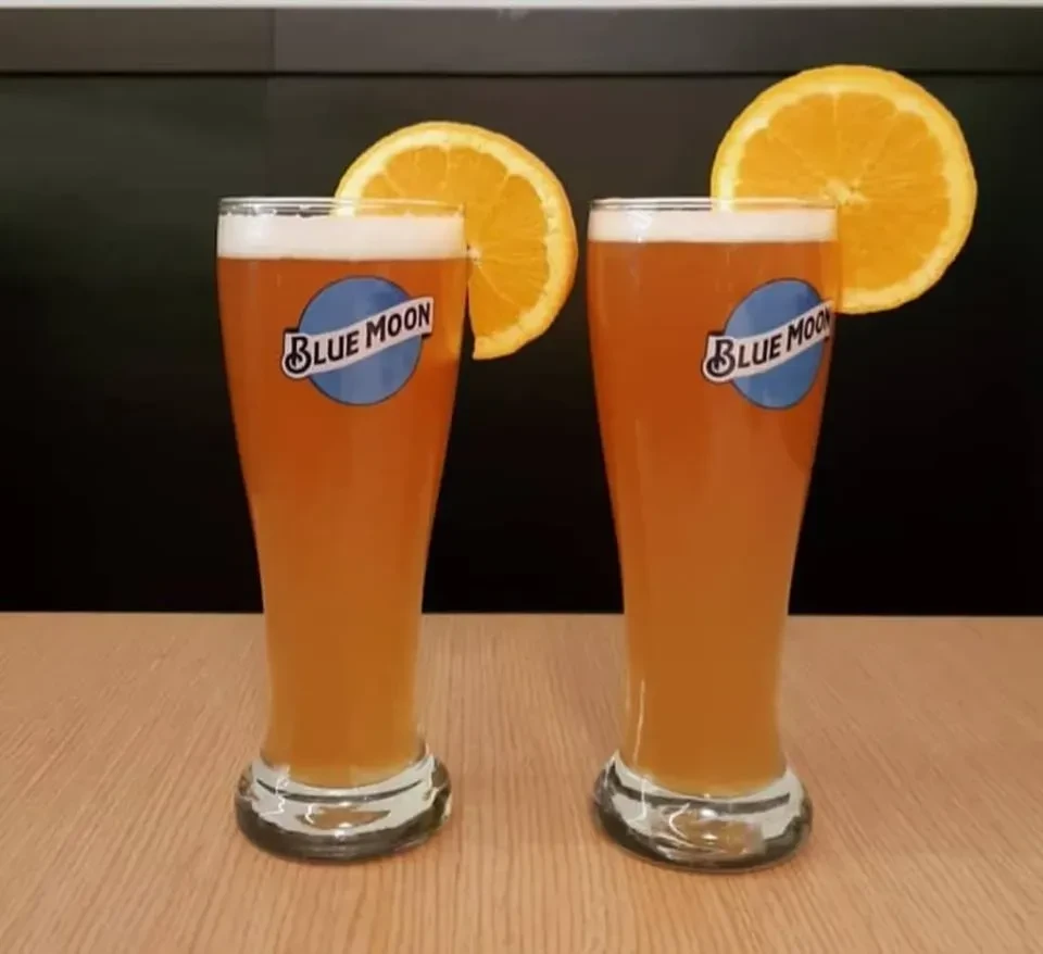 Two branded Blue Moon beers garnished with orange slices.