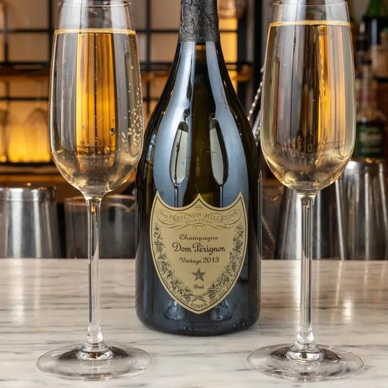 Dom Pérignon 2013 champagne bottle and two flutes with champagne.