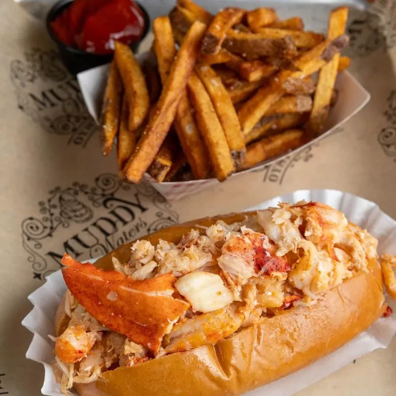 Lobster roll and french fries with ketchup on a Muddy Water's tray.