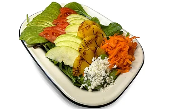 Deconstructed salad with avocado, tomato, apple, pineapple, carrots, and feta.