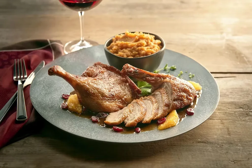 Duck leg and breast in sauce with cranberries, oranges, sweet potato.