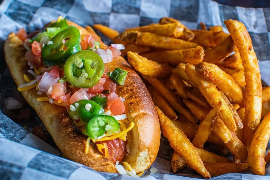 Grilled hot dog with jalapeños, pico de gallo, cheese, and french fries.