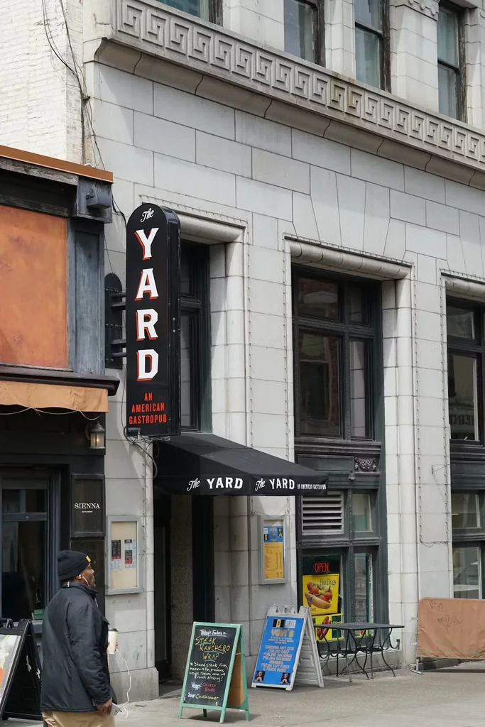 Facade of The Yard gastropub with signage, awning, and outdoor seating.