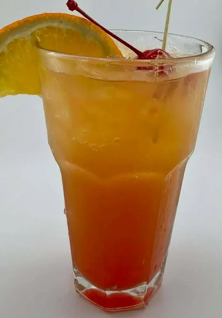 Cold layered gradient drink with ice, orange slice, and cherry.