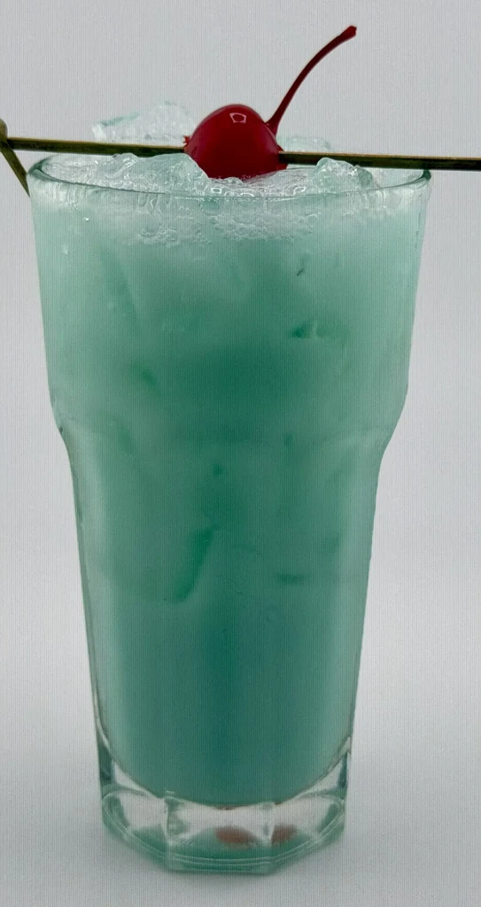 Frothy aqua drink with crushed ice and a red maraschino cherry.