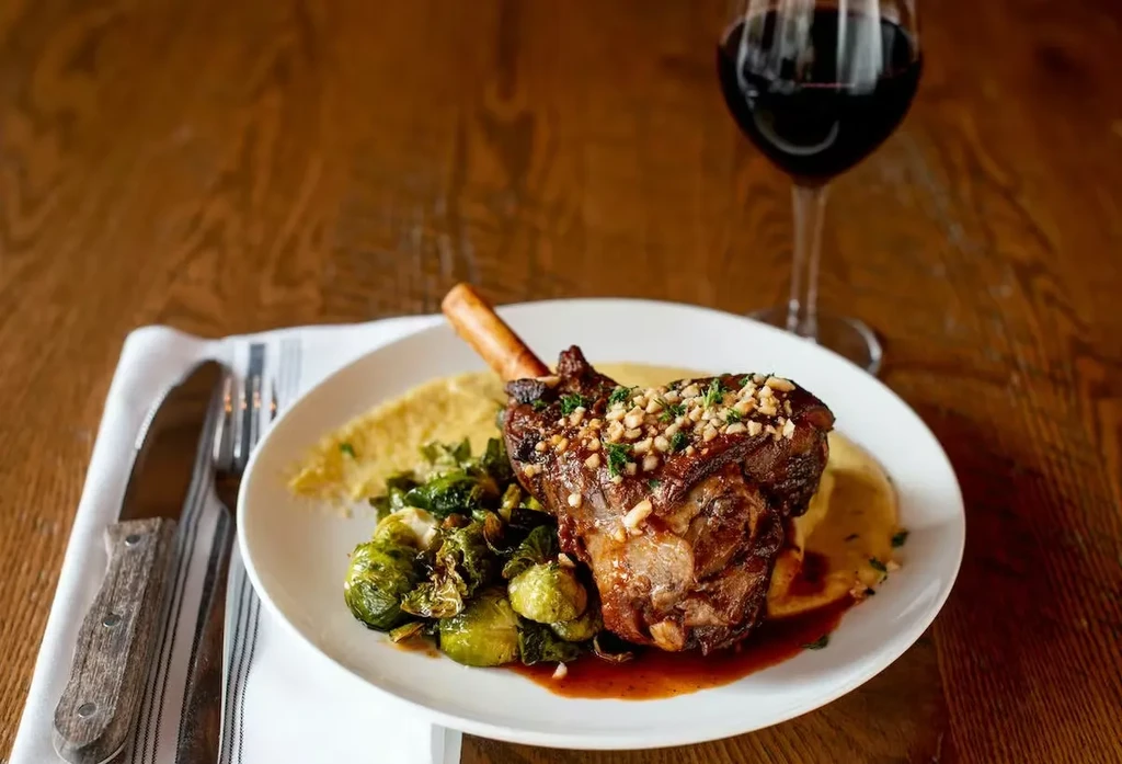 Braised meat with bone, Brussels sprouts, purée, and sauce.
