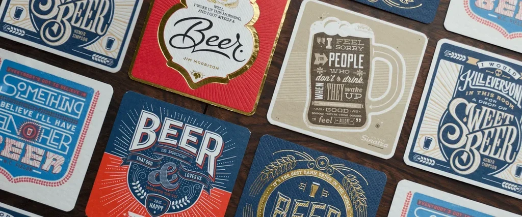 Vintage beer coasters arranged on a dark wooden table.