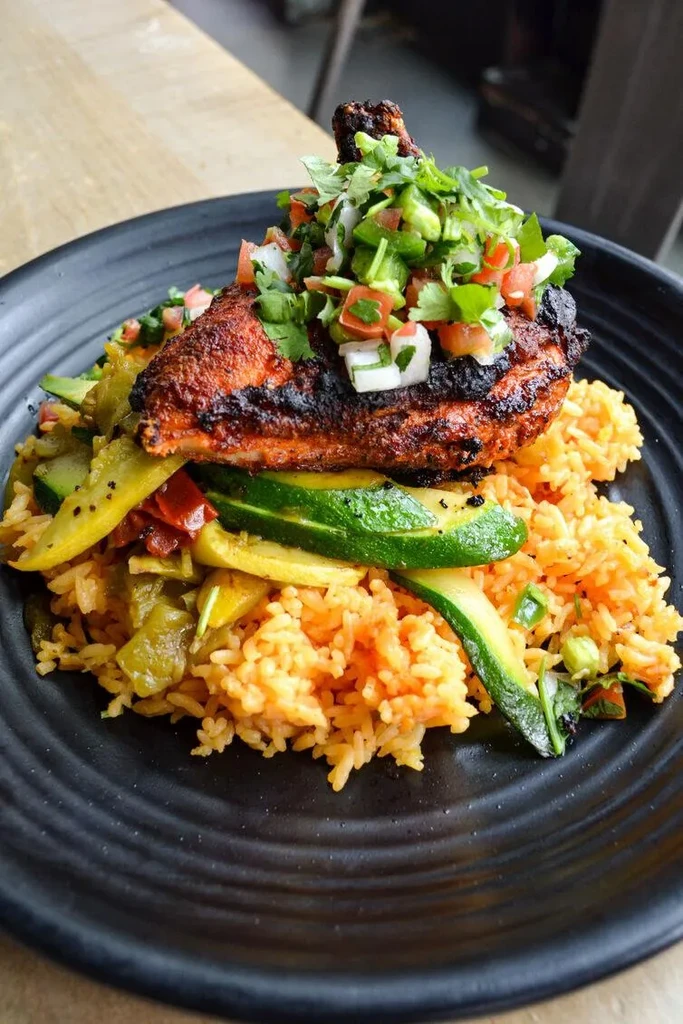 Top-down grilled chicken, fresh salsa, rice, and roasted vegetables.
