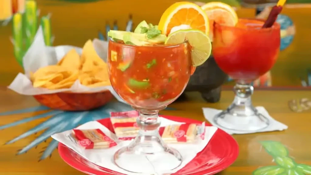 Garnished seafood cocktail, tortilla chips, and drinks in a colorful Mexican restaurant.