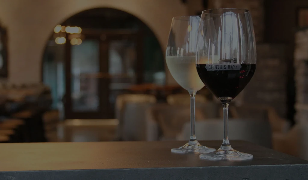 White and red wine glasses, one with 'EIGHTH & HAYS' logo.