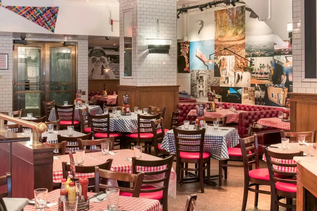 Empty restaurant dining area with checkered tables and red seating.