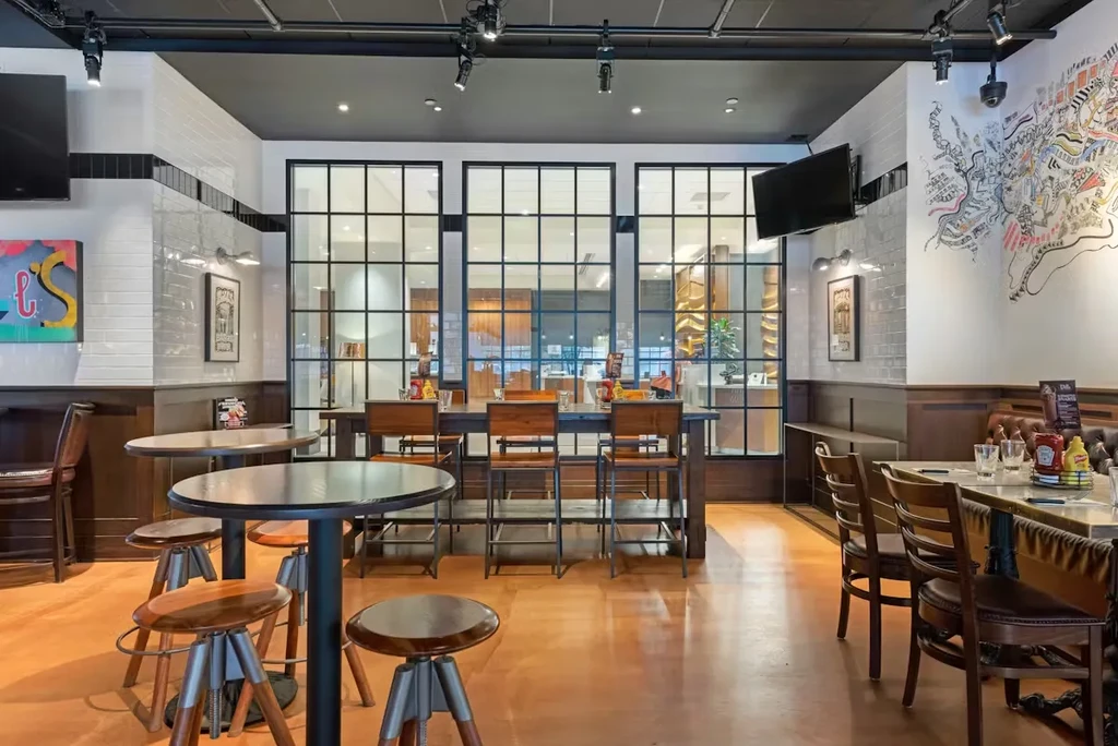 Empty modern restaurant interior with various seating, tiles, and dark wood.