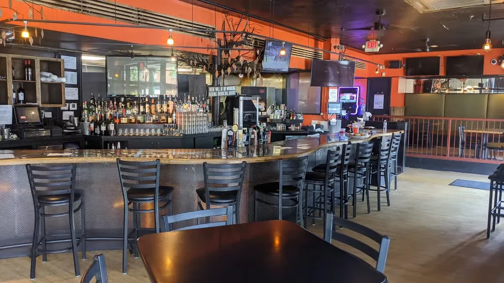 Empty modern bar with long curved counter and industrial design.