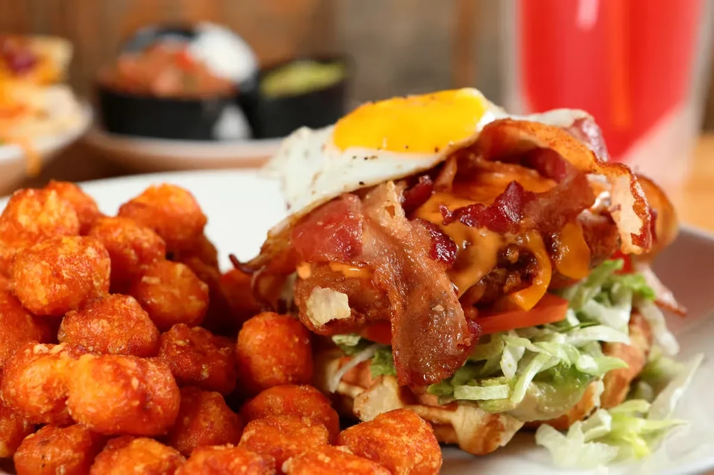 Hearty sandwich with bacon, egg, and cheese, served with tater tots.