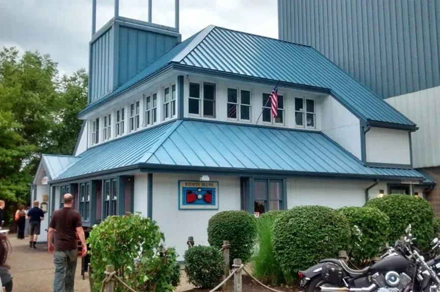 REDFIN BLUES restaurant with blue roof, white siding, and parked motorcycle.