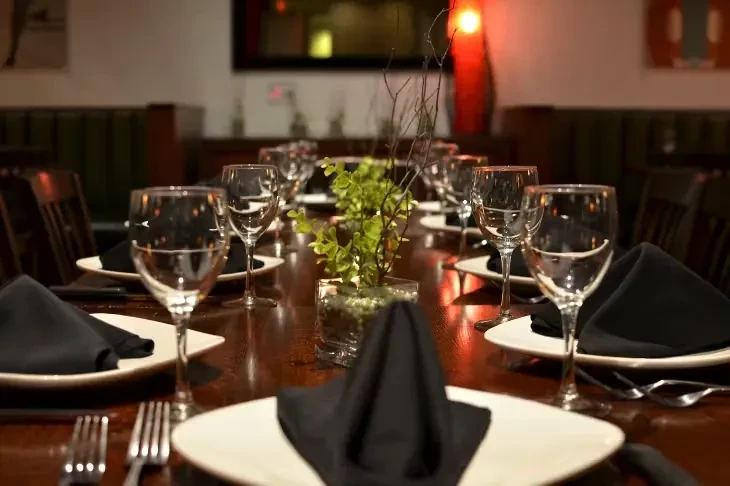 Elegantly set dining table with symmetrical place settings in a restaurant.