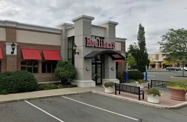 Houlihan's restaurant exterior with pillars, red sign, and red awnings.
