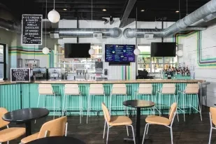 Modern ice cream shop interior with mint-green counter and digital menus.