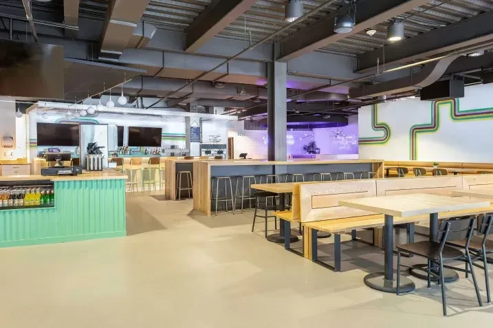 Spacious, empty modern restaurant/bar with industrial design and colorful art.