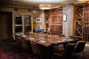 Elegant private dining room featuring a live-edge table and extensive wine storage.