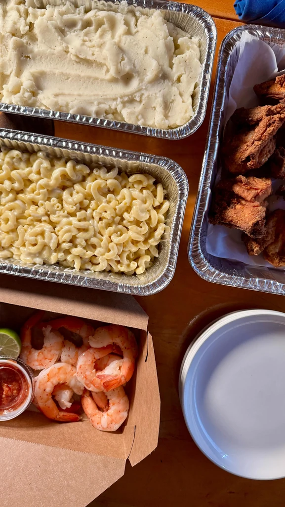 Overhead shot of catered mashed potatoes, mac and cheese, fried chicken, and shrimp.
