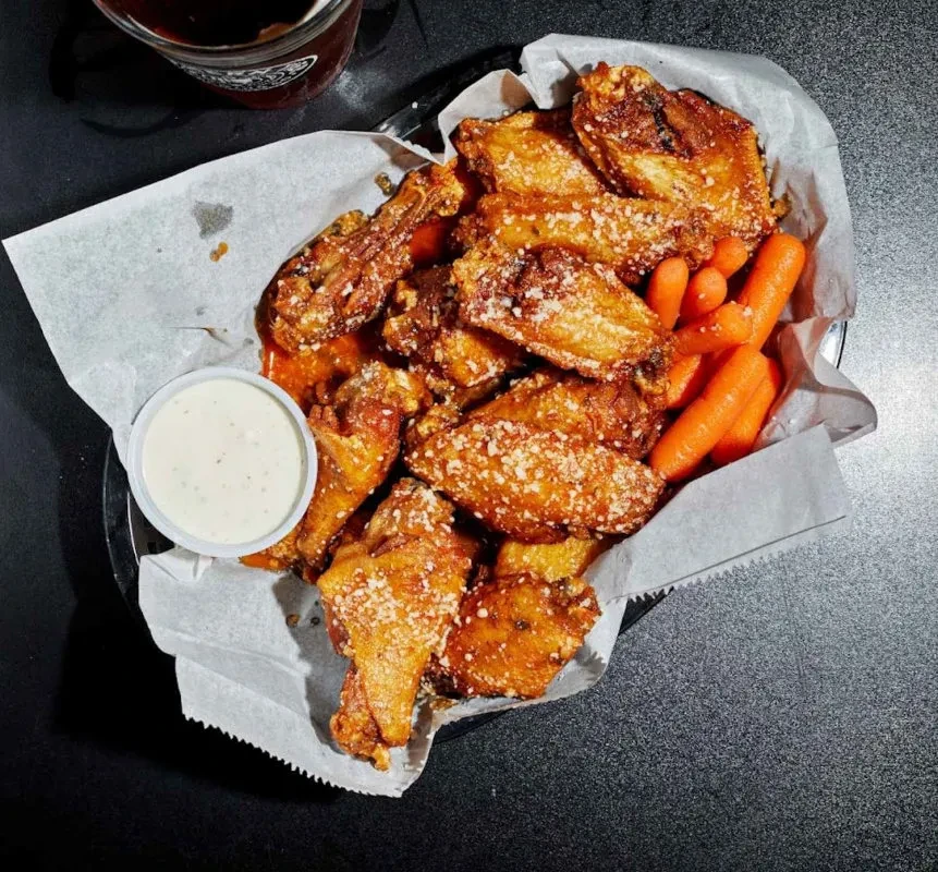 Golden-brown chicken wings with Parmesan, baby carrots, and creamy dipping sauce.